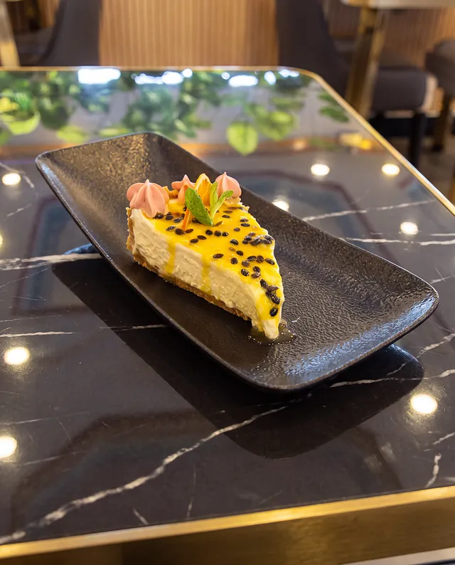 Cheesecake de maracuyá sobre pizarra negra