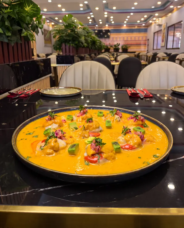 Conchitas en crema anaranjada con palta, sobre la mesa de mármol