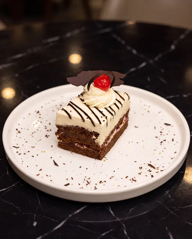 Torta de chocolate con crema y guinda